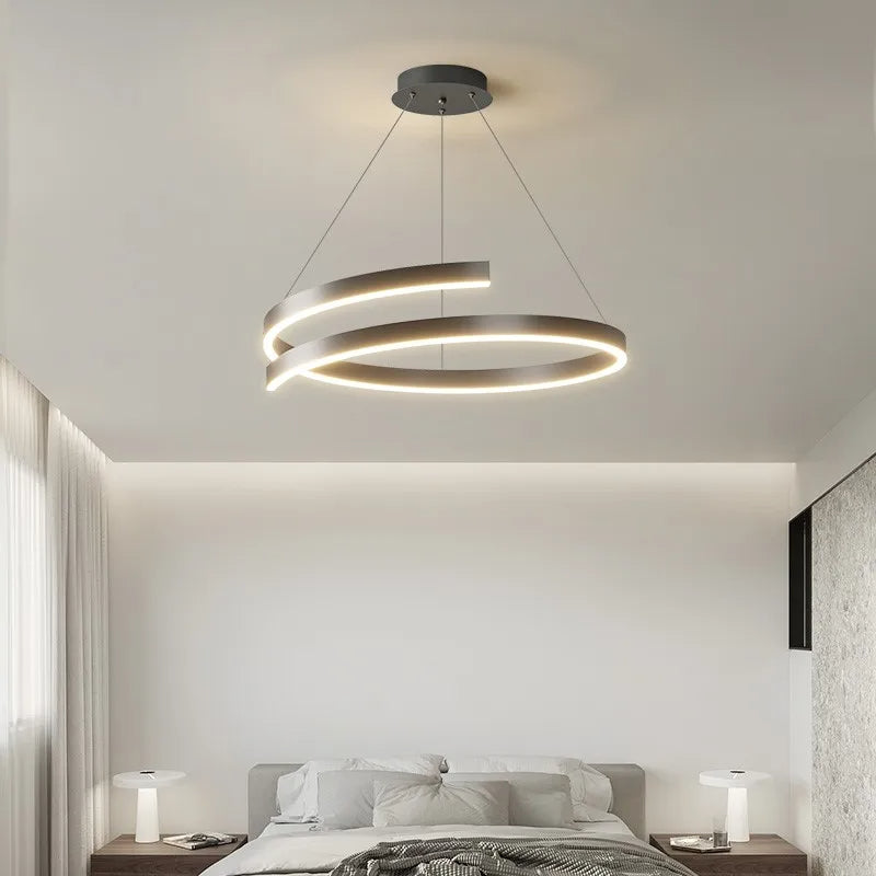 Black modern pendant light with adjustable dimmable LED rings in a bedroom