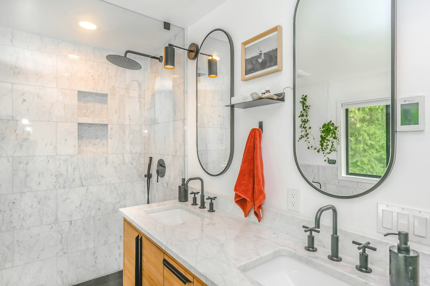 Contemporary bathroom with marble accents, dual sinks, and modern black fixtures