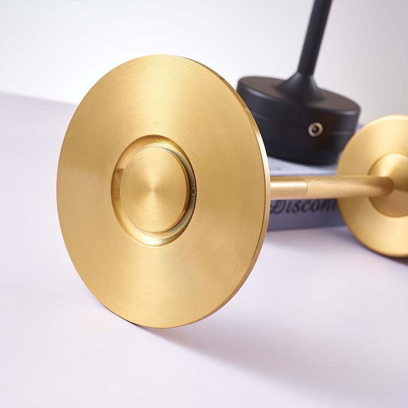 Close-up of the base and brass finish of a cordless table lamp, showcasing its elegant metal design.