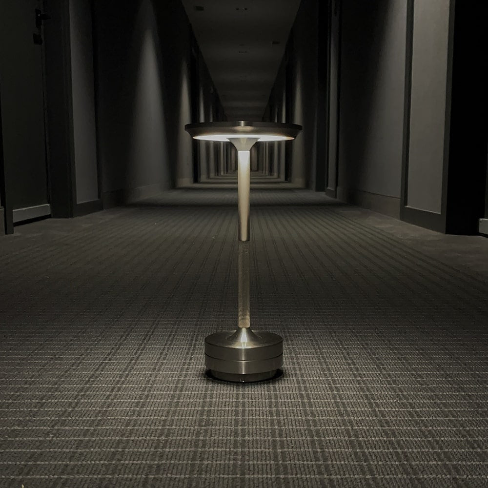 Cordless table lamp with a sleek black finish in a modern hallway setting.