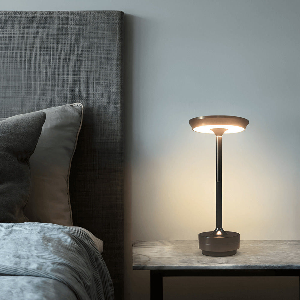 Modern rechargeable cordless table lamp on a bedside table in a minimalist bedroom