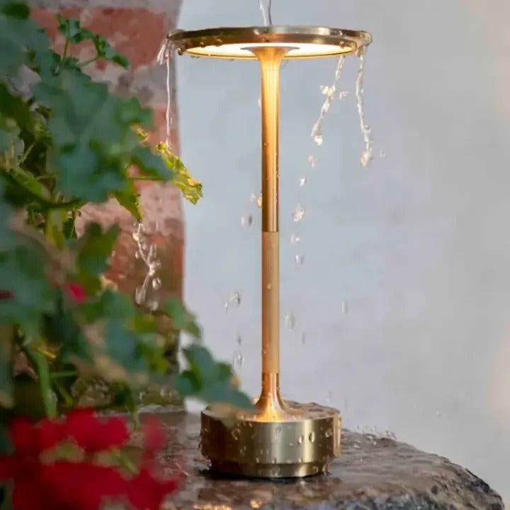 Outdoor cordless table lamp in brass, water-resistant design, ideal for patios and garden lighting.