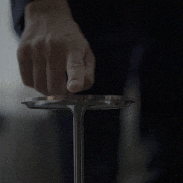 A hand touching the top of a cordless table lamp, demonstrating touch-sensitive dimming functionality.