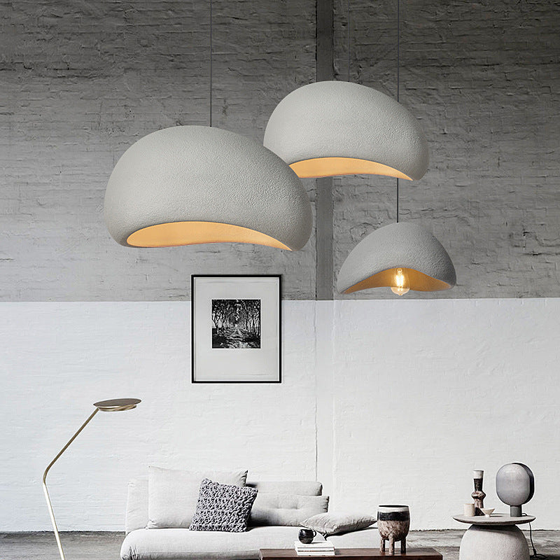 Trio of minimalist chandeliers in a loft setting, offering a modern and industrial ambiance with warm lighting.