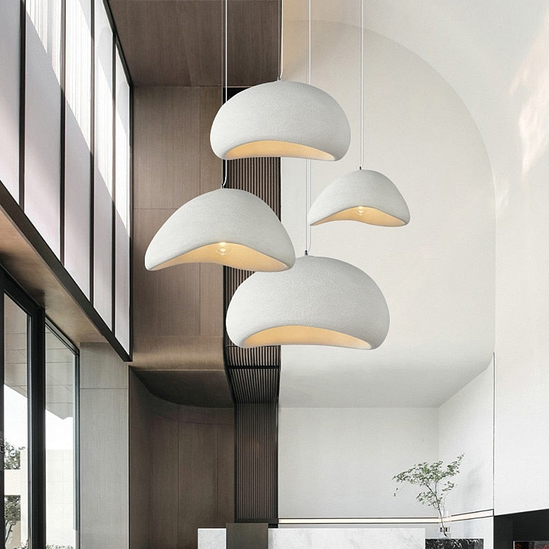 Set of four minimalist wabi-sabi pendant lights hanging in a modern interior, providing warm and elegant lighting.