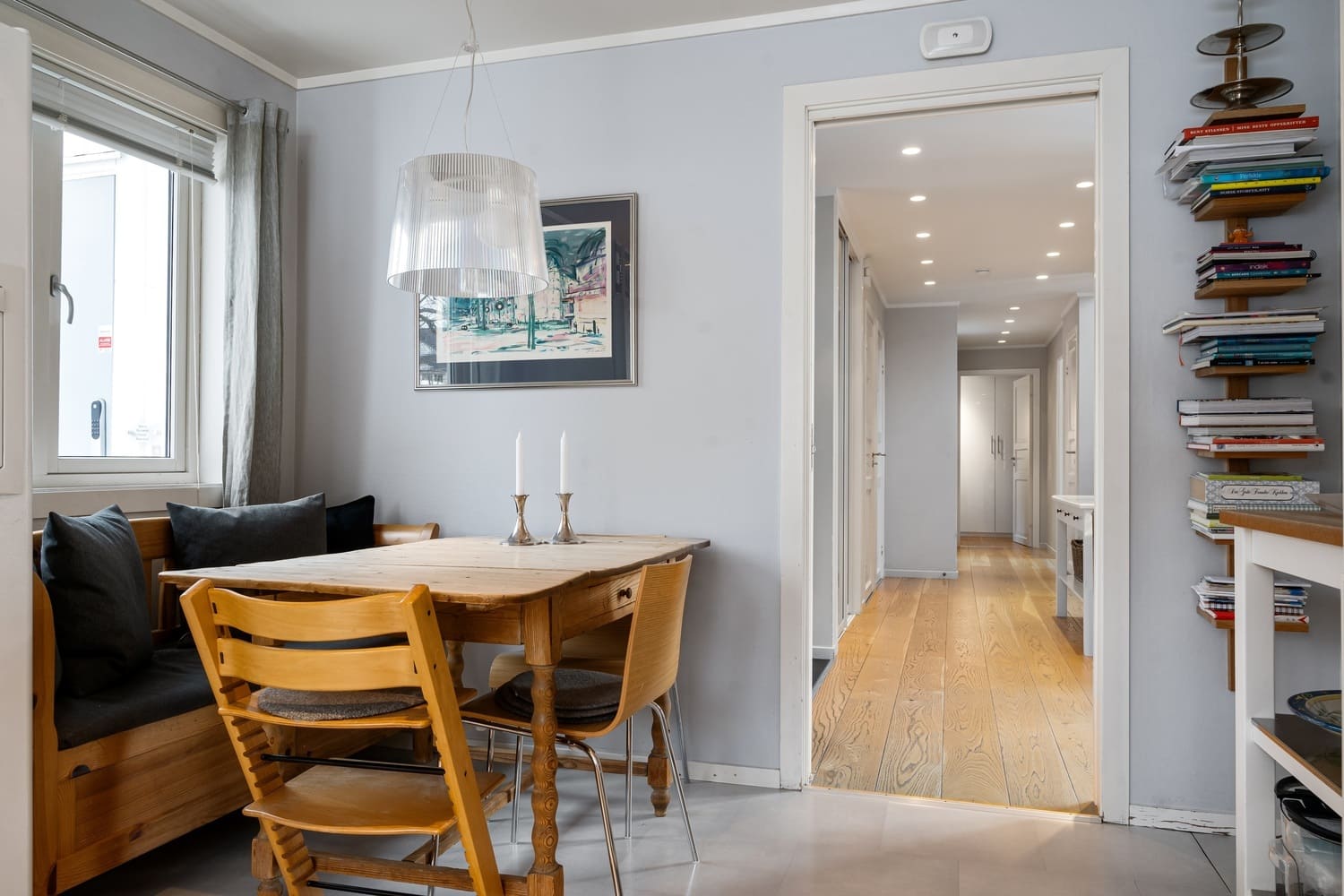 Small dining area with custom lighting and Scandinavian-style furniture.